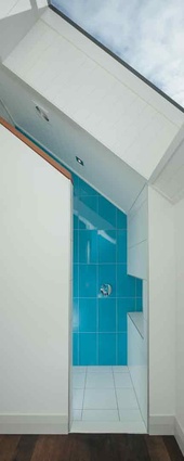 The bathroom shared by the children has bold sky-blue tiles. 