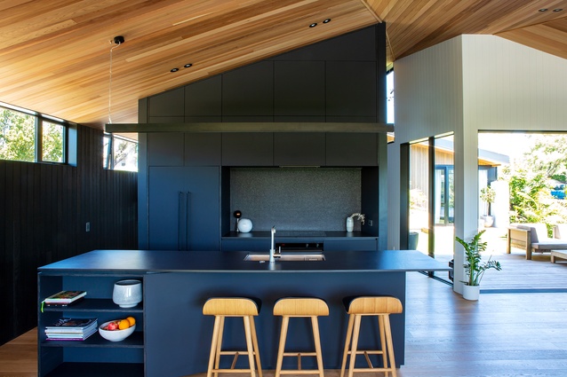 The black materials in the kitchen are juxtaposed with timber on the walls, floors and ceilings.