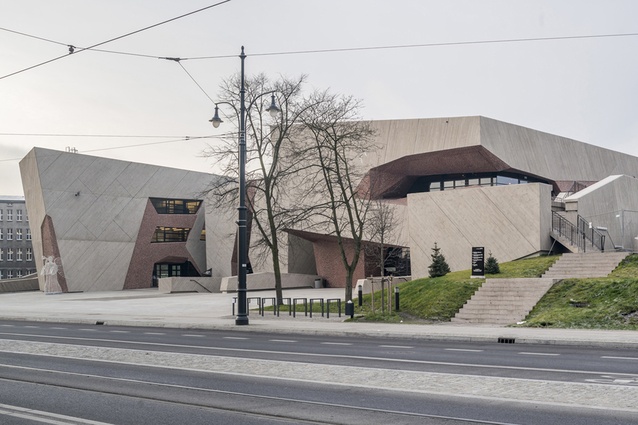 CKK Jordanki auditorium, Poland. Cut-away features in the pale concrete façade allow a peek into the reddish tones of the interior, and the stage can be opened onto the park for outdoor concerts.