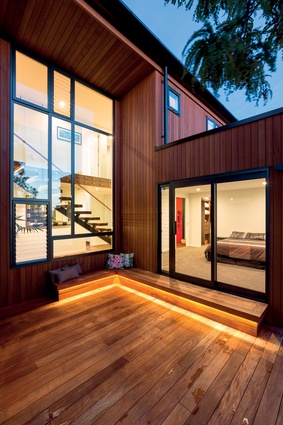 A Mondrian-style window overlooks the west-facing deck, breaking up the verticality of the cedar cladding and admitting an abundance of natural light into the home. 