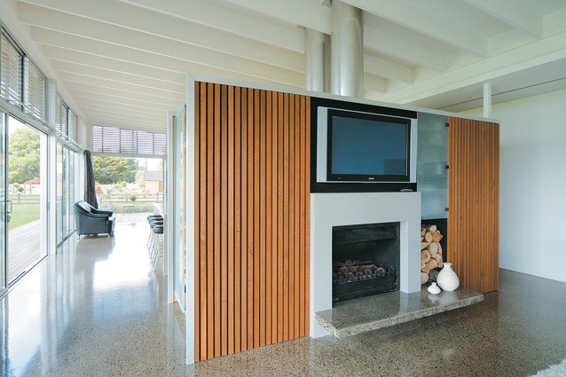 The interior is one long space divided into living and kitchen/dining areas by freestanding slatted walls.