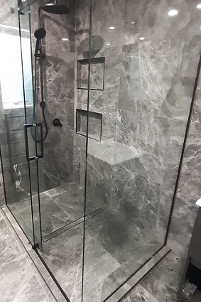 The glass channel is custom made and measured on-site before being installed directly on the waterproofed shower system.