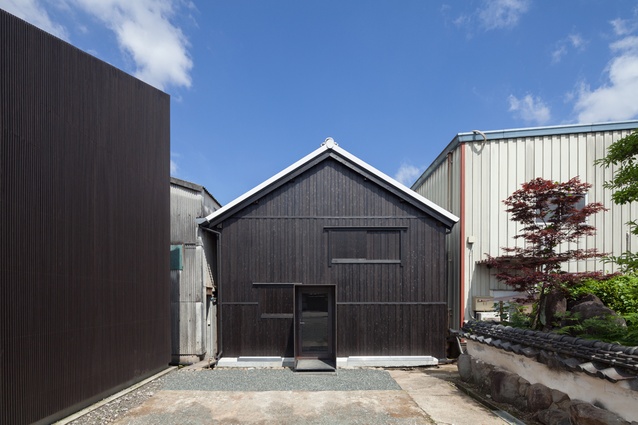 Fukuchiyo sake brewery in Japan by yHa architects. Architects converted a disused sake brewery into a tasting and exhibition space by adding a steel cuboid, interior walls and a mezzanine level.