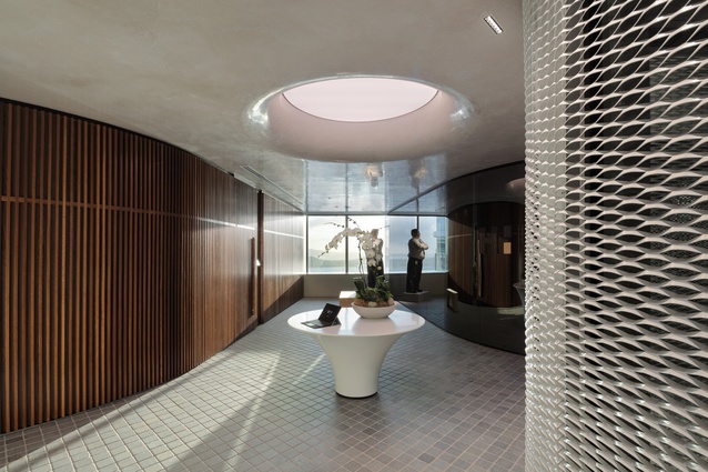 The arrival area features a balance of varying textures, such as tumbled stone pavers, American white oak timber battens, a curved smoky brass mirror and a polished lime plaster ceiling. 