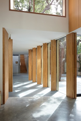Timber support columns provide framed views of the courtyard. 