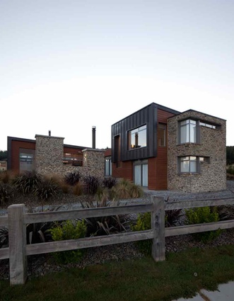 The house is clad in materials that suit the local form: schist, cedar and colorsteel.