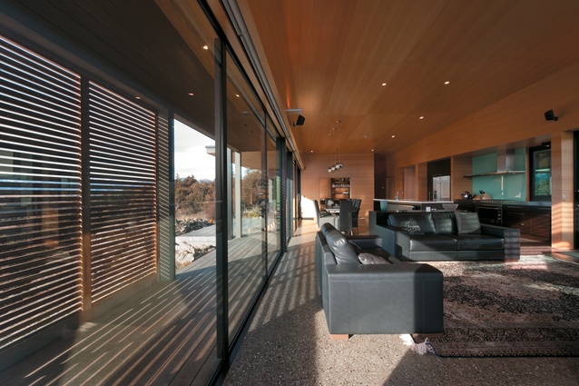 Looking from the living space towards the dining and kitchen. The external screens aid to blend the definition between the building and landscape. 